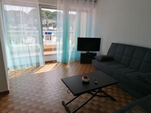 a living room with a couch and a table and a tv at Marina Port Camargue in Le Grau-du-Roi