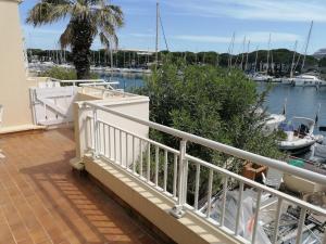 un balcón con una barandilla blanca junto a un puerto deportivo en Marina Port Camargue en Le Grau-du-Roi