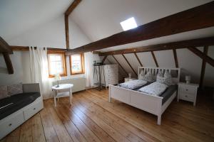 1 dormitorio con 1 cama y suelo de madera en Schulhaus Wettges, en Birstein