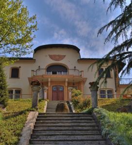 una casa grande con escaleras que conducen a ella en Villa La Meridiana en Alba
