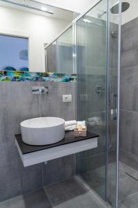 een badkamer met een wastafel en een glazen douche bij Damè - Accommodation Amalfi Coast in Maiori