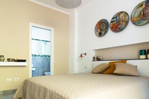 een slaapkamer met een bed en twee borden aan de muur bij Damè - Accommodation Amalfi Coast in Maiori