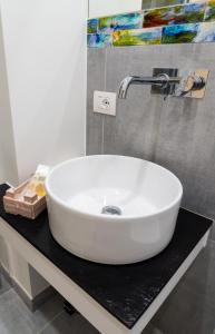 a white sink on a black counter in a bathroom at Damè - Accommodation Amalfi Coast in Maiori