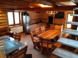 a kitchen and dining room with a wooden table and chairs at POD BRZĘCZĄCYMI TRZMIELAMI in Kombornia