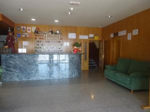 vestíbulo con bar y sofá verde en Hotel Restaurant Casa Miquel, en Alcarraz