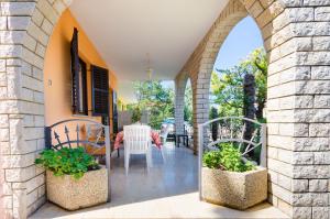 an archway leading to a patio with tables and chairs at Apartments Drago in Banjole