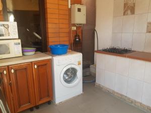a kitchen with a washing machine and a microwave at Guest house Norilchanka in Gelendzhik