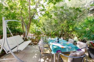 a patio with a table and chairs and a swing at Apartments Massimo in Rovinj