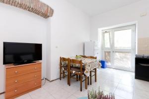 a living room with a dining room table and a television at Apartments Massimo in Rovinj