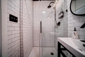 uma casa de banho branca com um chuveiro e um lavatório. em Artsy Hidden Gem -- FREE PARKING em Filadélfia