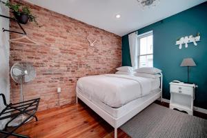 Un dormitorio con una pared de ladrillo y una cama en Artsy Hidden Gem -- FREE PARKING en Filadelfia