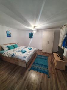 ein Schlafzimmer mit einem Bett und einem TV in der Unterkunft Casa Pavel Jurilovca in Jurilovca