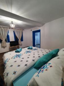 ein Schlafzimmer mit einem großen weißen Bett mit blauen Kissen in der Unterkunft Casa Pavel Jurilovca in Jurilovca