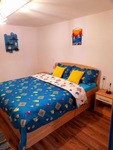 a bedroom with a bed with a blue comforter at Casa Pavel Jurilovca in Jurilovca