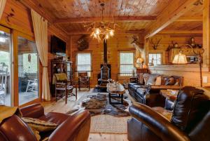 - un salon avec des meubles en cuir dans une cabane en rondins dans l'établissement Bearfeet Retreat, à Hot Springs