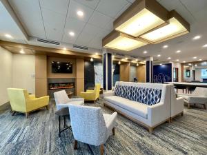 eine Lobby mit Stühlen, einem Sofa und einem Tisch in der Unterkunft Holiday Inn Express & Suites - Ft. Smith - Airport, an IHG Hotel in Fort Smith