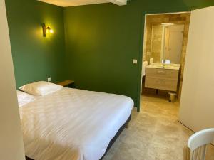 een groene slaapkamer met een bed en een wastafel bij La Clef des Champs in Jugeals-Nazareth