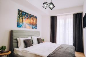 een slaapkamer met een bed en een schilderij aan de muur bij Luxury Apartments Stefano - Elite in Ohrid