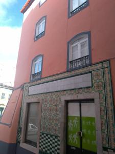 a pink building with tiles on the facade at Casa do Arco da Praça in Elvas