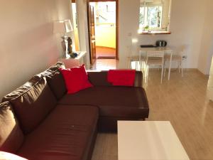 een woonkamer met een bruine bank en rode kussens bij Sitio de Calahonda Calahonda Royale Mijas Costa Spain in Mijas