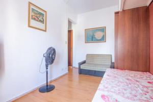 a bedroom with a bed and a fan in a room at Apartamento Arouche in São Paulo
