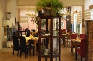 - une salle à manger avec des tables et des chaises dans l'établissement Arthotel Landhaus Zur Alten Gärtnerei, à Zossen