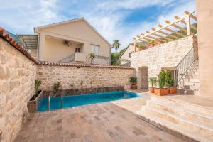 a villa with a swimming pool and stairs at Apartments Gabela in Risan