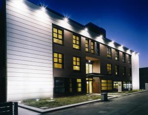 un bâtiment avec des lumières sur son côté dans l'établissement HC3 Hotel, à Bologne