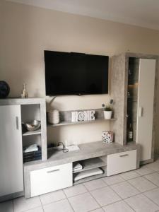a white entertainment center with a tv on a wall at Rocas del Mar Apartment in Costa Del Silencio