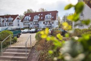 uma fila de casas e carros estacionados num parque de estacionamento em RR - Tiny Apartment - Parking - Kitchen - Netflix em Magdeburg