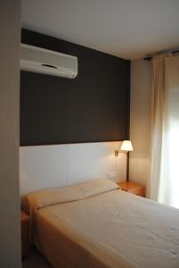 a bedroom with a bed with a black wall at Hotel Sant Jordi in Segur de Calafell