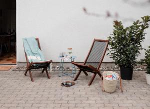 une paire de chaises et une table avec un verre de vin dans l'établissement ☆Reif für die Insel? Cozy Apartment auf Usedom, à Karlshagen