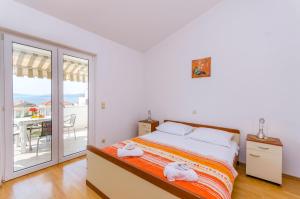 a bedroom with a bed and a balcony with a table at Apartments Tily in Trogir