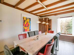 een eetkamer met een houten tafel en stoelen bij Holiday home near the Efteling with garden in Nieuwkuijk