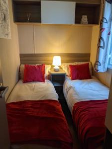 - 2 lits dans une chambre avec une lampe sur une table dans l'établissement 17 Sun Valley Holiday Park, à St Austell