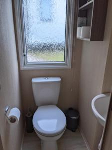 Elle comprend une petite salle de bains pourvue de toilettes et d'une fenêtre. dans l'établissement 17 Sun Valley Holiday Park, à St Austell