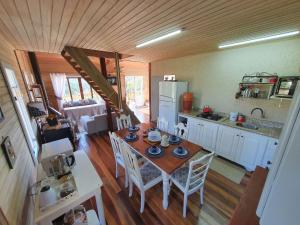 uma cozinha e sala de jantar com mesa e cadeiras em Cabana Pôr-do-Sol - Rancho Queimado/SC em Rancho Queimado