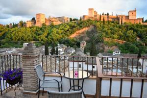 a balcony with a table and chairs and a castle at Apartamentos Alhambra in Granada