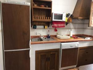 una pequeña cocina con fregadero y microondas en CASA RURAL LA CABRERA, en Casas del Castañar