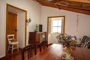 a dining room with a table and a television at Graciosa Family House in Santa Cruz da Graciosa