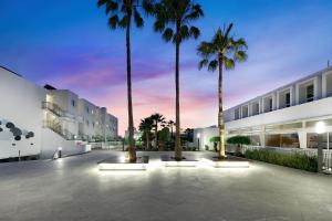 
a large building with palm trees and palm trees at Aequora Lanzarote Suites in Puerto del Carmen
