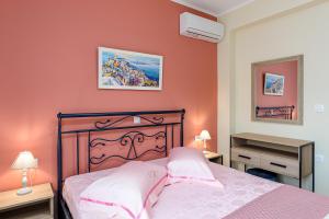 a bedroom with a bed with pink walls and a piano at Stella Maris - Sivota Holiday Home in Sivota