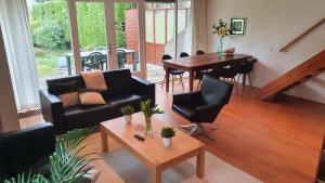 a living room with a couch and a table at Lake House 19 relax accommodation in Warmond