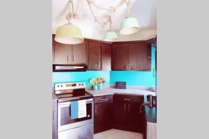 a kitchen with brown cabinets and white appliances at Sol-O-Cien Estrella in Rosarito