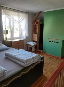 a bedroom with a large bed and a window at Domek na Mazurach Ełk. Rogale in Stare Juchy