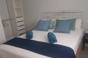 una camera da letto con un grande letto con cuscini blu di Recién reformado, bien situado y comunicado a San Fernando