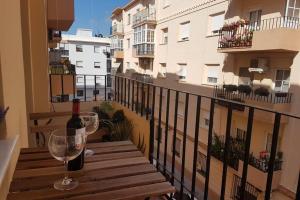 a bottle of wine and a glass on a balcony at La Isla Centro II in San Fernando