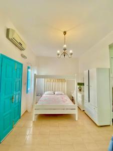 a bedroom with a white bed and a blue door at Sevasti Studios in Panormos Kalymnos