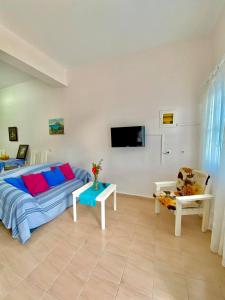 a living room with a bed and a tv on the wall at Sevasti Studios in Panormos Kalymnos
