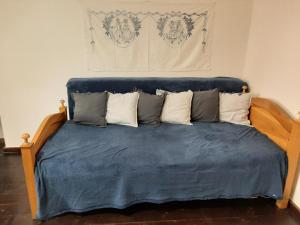 a bed with blue sheets and pillows on it at Babičkin Dom in Medzilaborce
